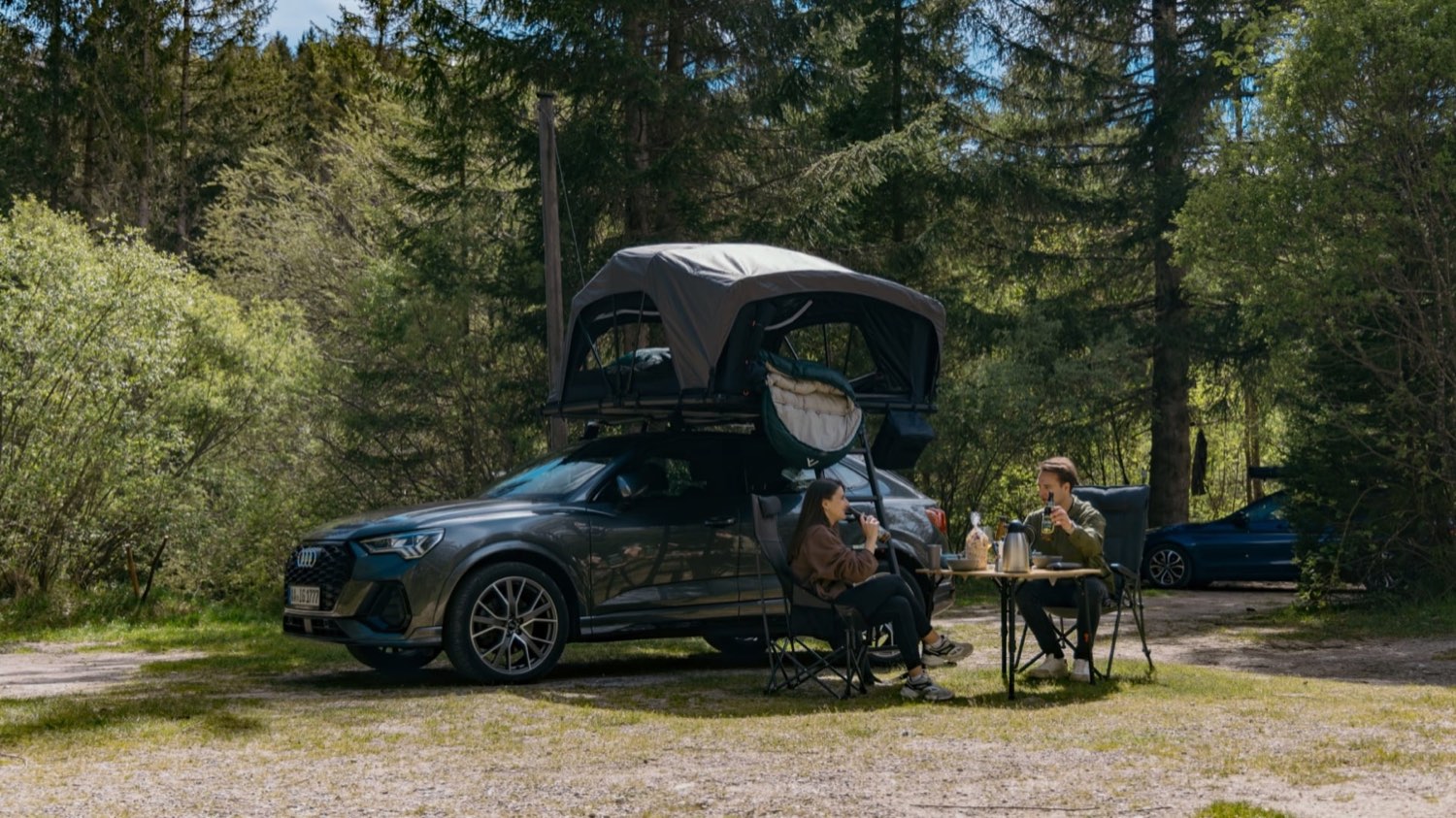 Paar richtet das Dachzelt auf dem Auto im Wald ein